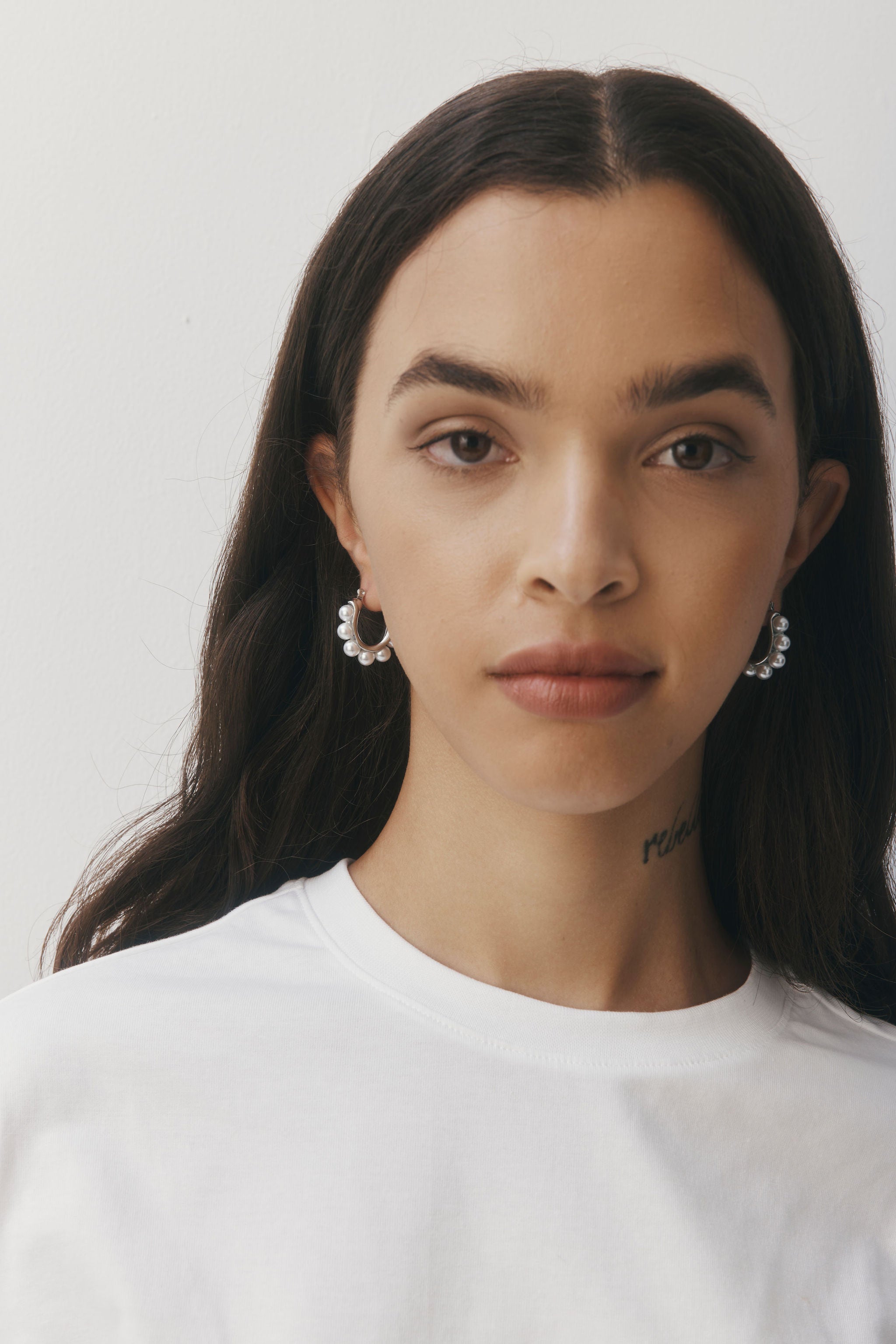 Margot Earrings by Castel & Co feature a softly sculpted gold-plated stainless steel hoop finished with a luminous imitation pearl drop. Designed to feel both modern and timeless, they bring a refined edge to everyday styling while also suiting occasion wear. Measuring 2.4 x 2.6 cm with a secure hinge closure. Lightweight (10g), waterproof, and hypoallergenic.