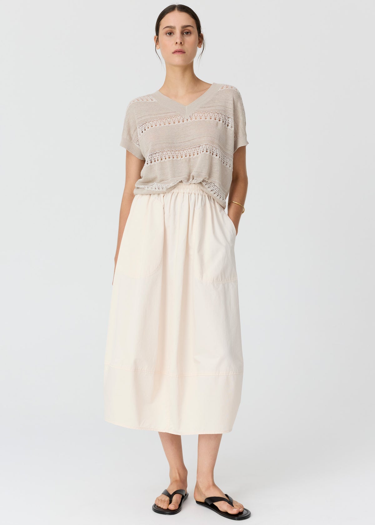 Shop the POL Liana V-Neck Pointelle Knit - a 100% cotton oversized knit with intricate pointelle stripes, semi-sheer detailing and a relaxed longline silhouette.