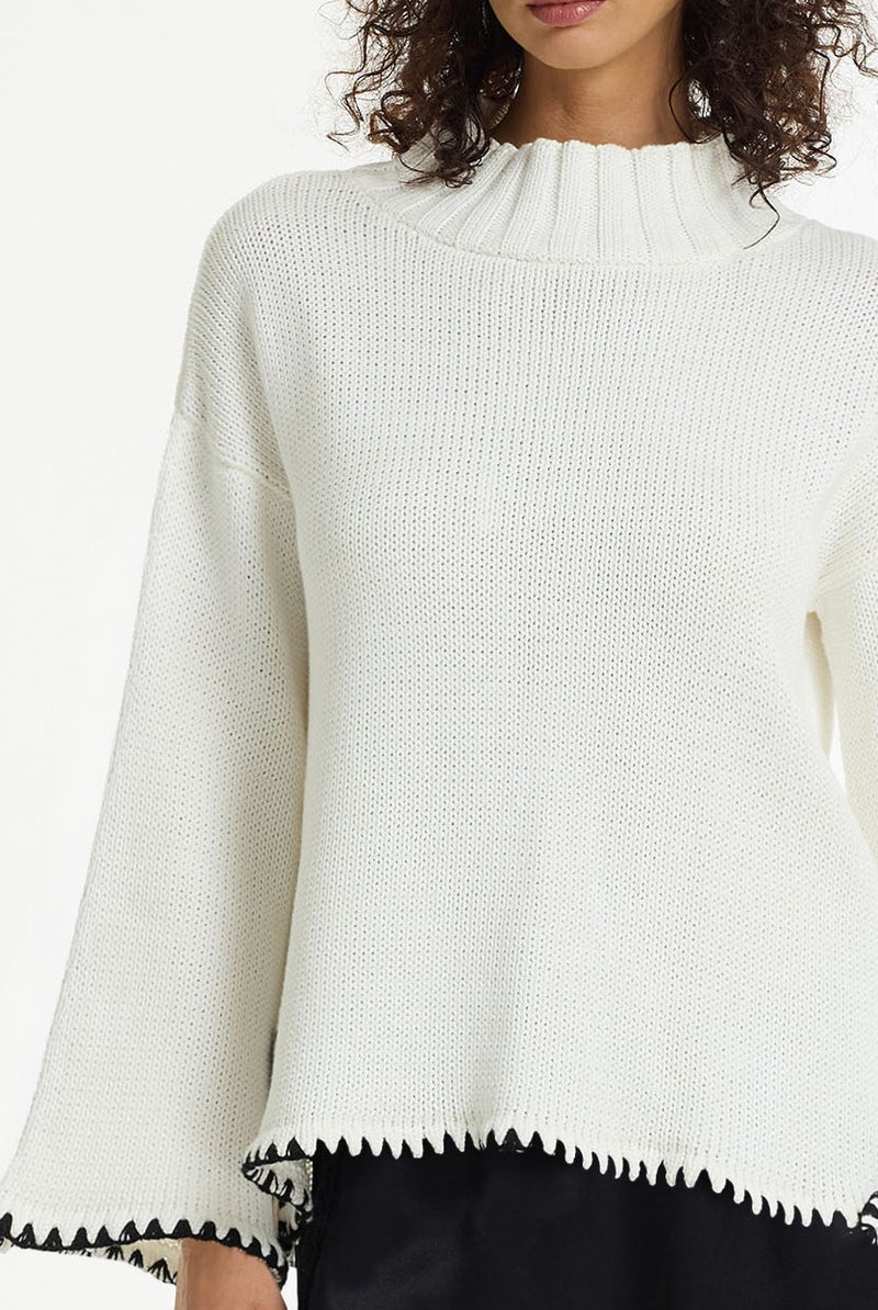 BLAK : The Vogue Cotton Sweater is a white cotton knit designed with black contrast stitching, wide sleeves and a relaxed, easy silhouette. Knitted from breathable cotton yarn, it has a soft mid-weight feel that makes it perfect for effortless layering across seasons. 