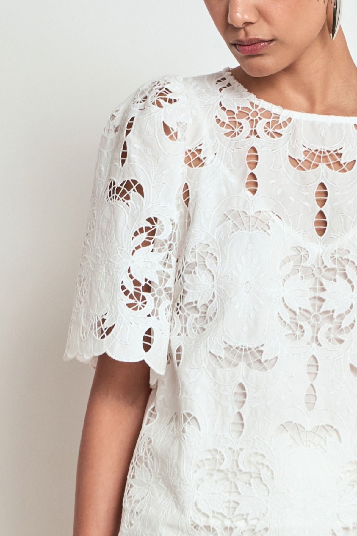 Discover the Zoe Kratzmann Resolve Top in Alabaster. Crafted from intricate 100% cotton lace with gathered short sleeves, a classic round neckline and cami included.