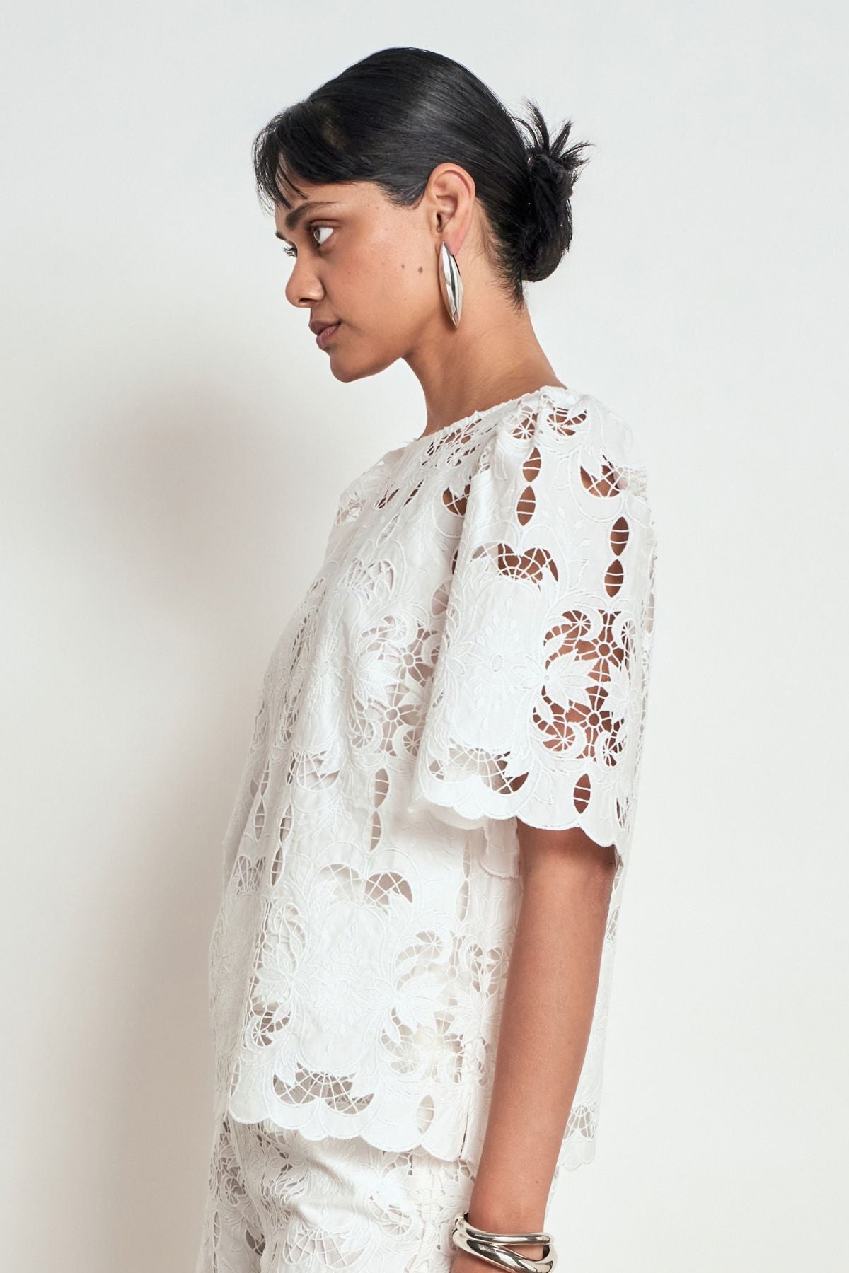 Discover the Zoe Kratzmann Resolve Top in Alabaster. Crafted from intricate 100% cotton lace with gathered short sleeves, a classic round neckline and cami included.