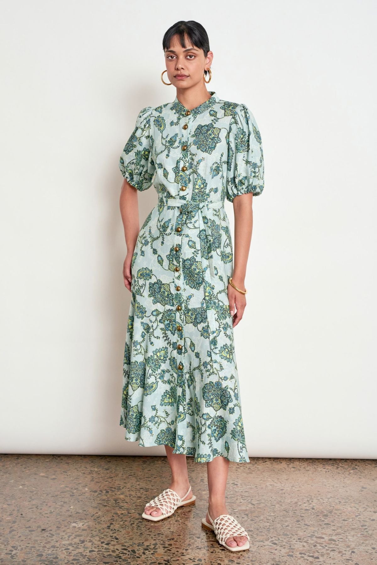 Discover the Zoe Kratzmann Cascade Dress in Fern Paisley. Crafted from 100% linen with antique brass buttons, gathered sleeves and a relaxed midi silhouette.