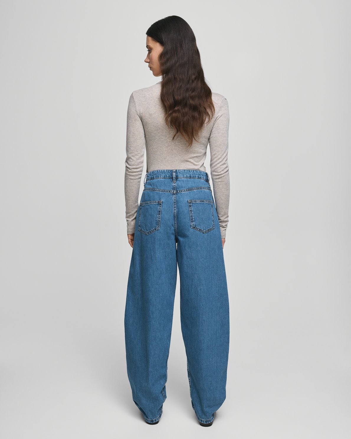 MSCH Copenhagen KOBANE LIS Barrel Jeans in washed blue denim with a loose barrel-leg fit, mid waist and tapered ankle. Features classic five-pocket styling, visible stitching, belt loops and zip button closure.