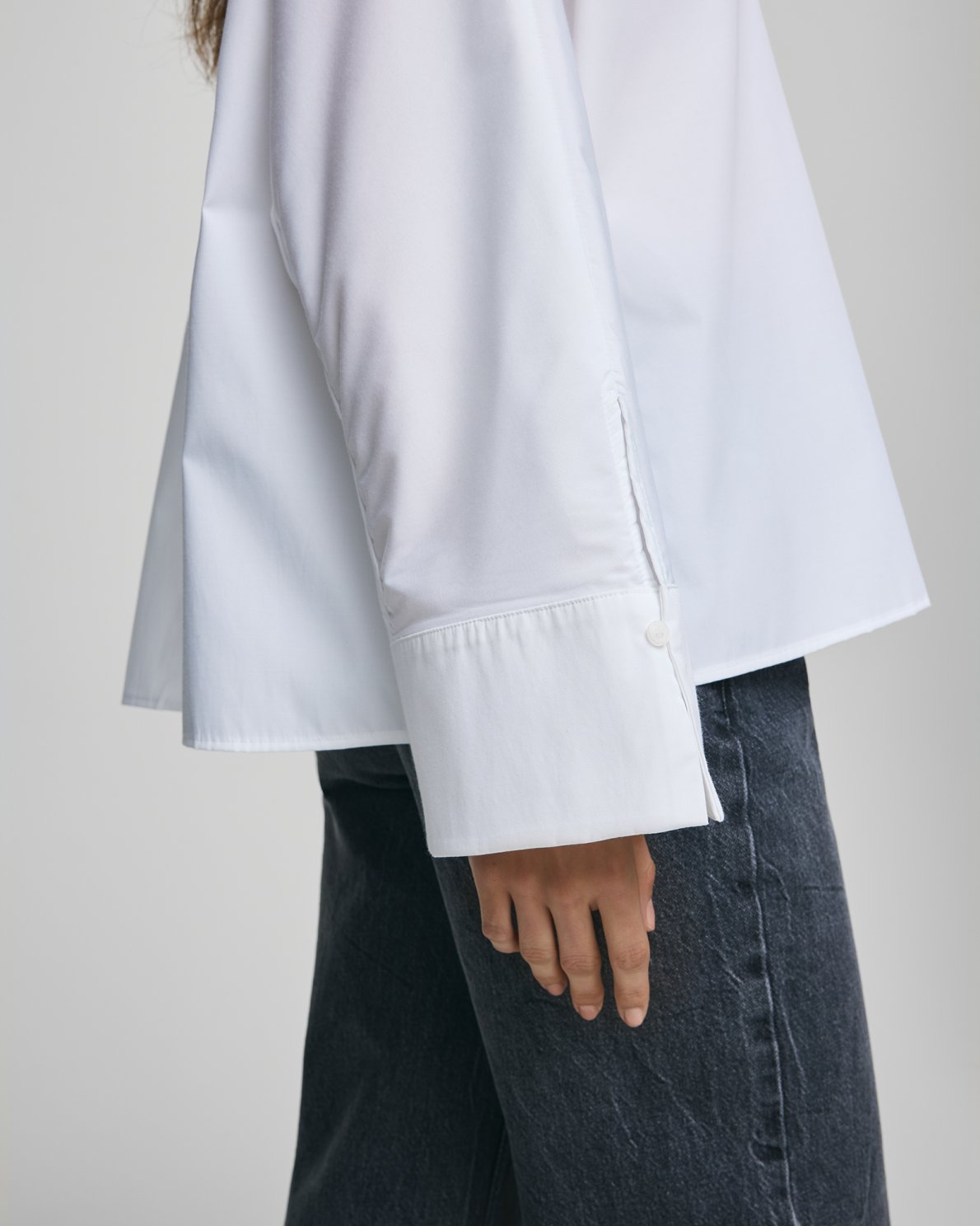 MSCH Copenhagen NATALIA ZENIKA Boxy Shirt in black with a clean structured silhouette, classic collar and full front button closure. Features long sleeves with wide cuffs and an adjustable back button detail to define the waist or wear loose. Crafted from a smooth recycled polyester and cotton blend.