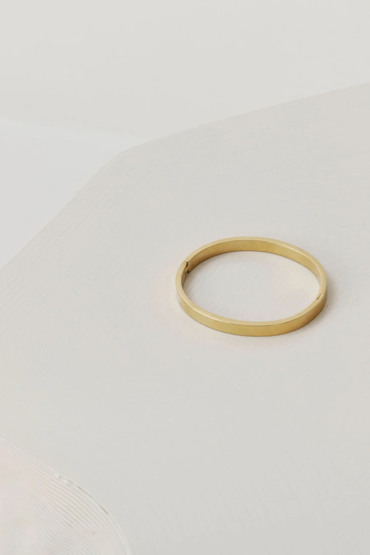RYLEE Bracelet by Castel & Co in gold with a slim, refined silhouette designed for effortless everyday wear. Clean and modern in feel, it sits neatly on the wrist, perfect for stacking or wearing on its own. Crafted from stainless steel with gold plating, featuring a 5.8 cm diameter and 0.4 cm width. Waterproof, hypoallergenic, and lightweight at 15g.