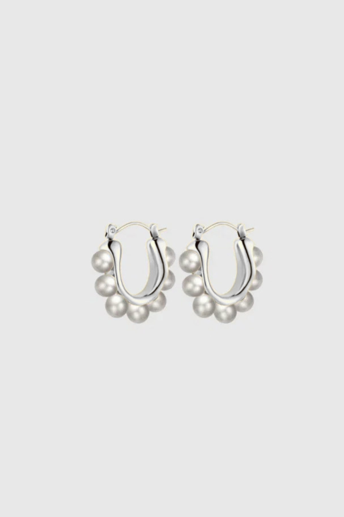 Margot Earrings by Castel & Co feature a softly sculpted gold-plated stainless steel hoop finished with a luminous imitation pearl drop. Designed to feel both modern and timeless, they bring a refined edge to everyday styling while also suiting occasion wear. Measuring 2.4 x 2.6 cm with a secure hinge closure. Lightweight (10g), waterproof, and hypoallergenic.